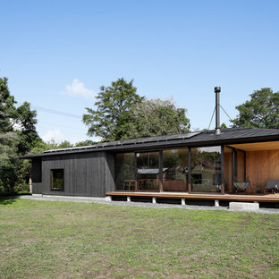Schwarzes, Einstöckiges Asiatisches Einfamilienhaus mit Holzfassade, Satteldach und Blechdach in Sonstige