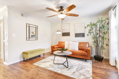 Small minimalist enclosed medium tone wood floor and brown floor living room photo in Atlanta with beige walls