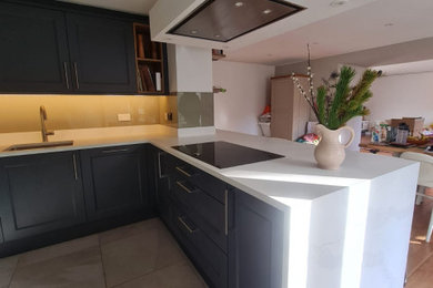Inspiration for a medium sized contemporary grey and white u-shaped open plan kitchen in Edinburgh with shaker cabinets, grey cabinets, quartz worktops, white worktops, a submerged sink, engineered quartz splashback, black appliances, ceramic flooring, multi-coloured floors, a drop ceiling and feature lighting.