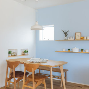 Immagine di una piccola sala da pranzo aperta verso il soggiorno scandinava con pareti blu, parquet chiaro, pavimento beige, soffitto in carta da parati e carta da parati