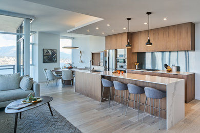 Photo of a mid-sized contemporary single-wall eat-in kitchen in Vancouver with flat-panel cabinets, medium wood cabinets, quartz benchtops, with island and white benchtop.
