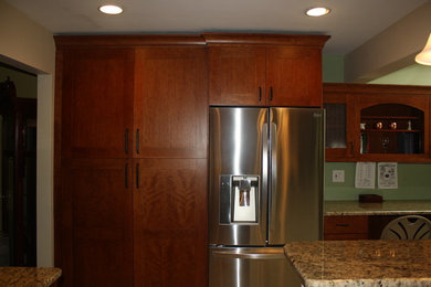 Inspiration for a large contemporary l-shaped medium tone wood floor eat-in kitchen remodel in New York with an undermount sink, shaker cabinets, medium tone wood cabinets, quartz countertops, beige backsplash, mosaic tile backsplash, stainless steel appliances and an island