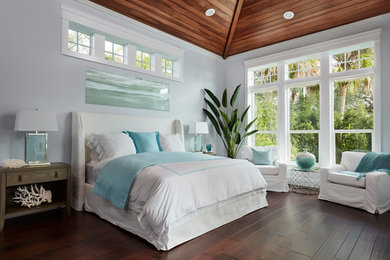 Large beach style master dark wood floor and brown floor bedroom photo in Miami with gray walls and no fireplace