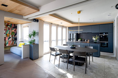 Modern galley open plan kitchen in Tokyo with a submerged sink, beaded cabinets, grey cabinets, black splashback, an island, grey floors and black worktops.