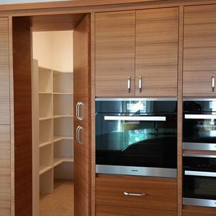 Large modern kitchen pantry ideas - Large minimalist porcelain floor kitchen pantry photo in Tampa with flat-panel cabinets, medium tone wood cabinets, granite countertops, beige backsplash, glass sheet backsplash and stainless steel appliances