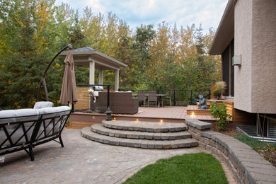 Foto de terraza planta baja contemporánea de tamaño medio en patio trasero con cocina exterior, pérgola y barandilla de metal