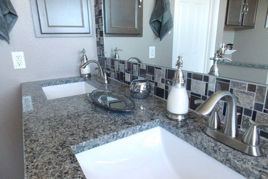 Mid-sized trendy master mosaic tile and gray tile porcelain tile corner shower photo in Austin with recessed-panel cabinets, dark wood cabinets, a two-piece toilet, gray walls, an undermount sink and granite countertops