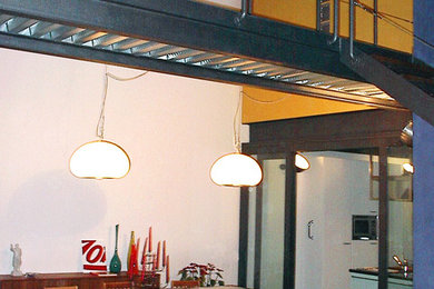 Diseño de comedor industrial grande abierto con paredes blancas y suelo de madera en tonos medios