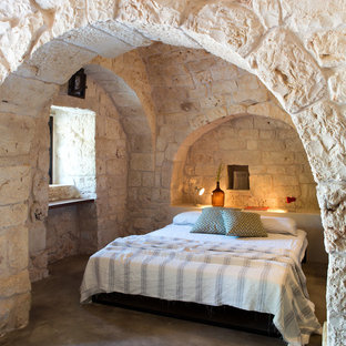 Mediterranes Hauptschlafzimmer ohne Kamin mit Betonboden und grauem Boden in Sonstige
