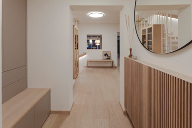 Kleiner Asiatischer Schmaler Flur mit weißer Wandfarbe, hellem Holzboden und beigem Boden in München