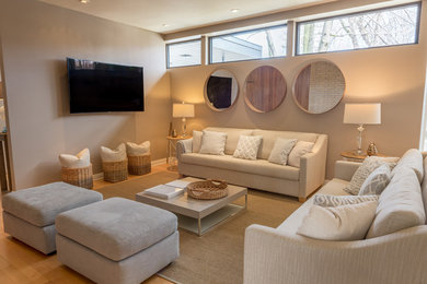 Example of a large trendy formal and loft-style light wood floor living room design in Montreal with beige walls and a wall-mounted tv
