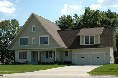 Example of a mid-sized arts and crafts green three-story concrete fiberboard gable roof design in Other
