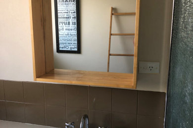 Photo of a small modern bathroom in Perth with light wood cabinets, a corner shower, a hinged shower door, an enclosed toilet, a single vanity and a floating vanity.