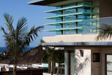 Inspiration for a mid-sized contemporary beige two-story stone flat roof remodel in San Diego