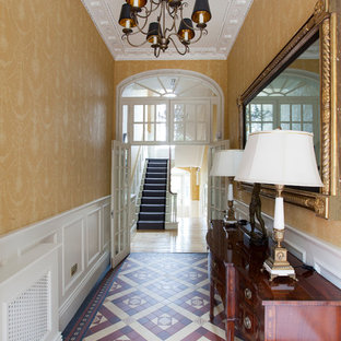 Exempel på en mellanstor klassisk hall, med gula väggar, linoleumgolv och flerfärgat golv