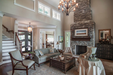 This is an example of a large traditional formal open concept living room in Charlotte with beige walls, medium hardwood floors, a standard fireplace, a stone fireplace surround and no tv.