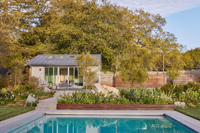 Design ideas for a mid-sized modern backyard concrete paver and wood fence lawn edging in San Francisco.