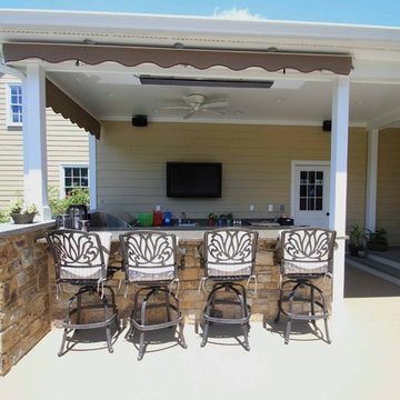 Kidney shaped in-ground salt water pool with outdoor kitchen