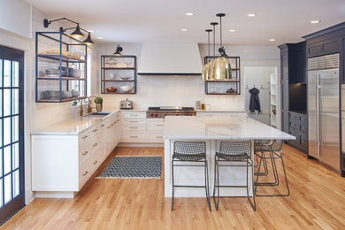 Example of a large transitional l-shaped light wood floor kitchen design in Minneapolis with an undermount sink, white cabinets, quartzite countertops, white backsplash, subway tile backsplash, stainless steel appliances, an island, white countertops and recessed-panel cabinets