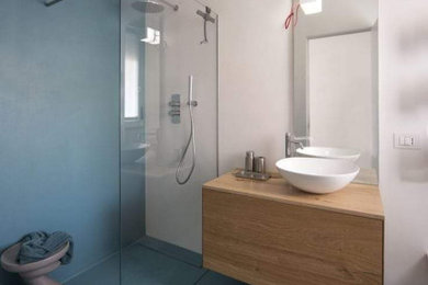 Idee per una piccola stanza da bagno con doccia minimalista con ante lisce, ante in legno chiaro, doccia a filo pavimento, WC a due pezzi, piastrelle di cemento, pareti bianche, pavimento in cemento, lavabo a bacinella, top in legno, pavimento turchese, doccia aperta, top beige, un lavabo e mobile bagno sospeso