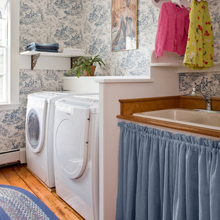 This is an example of a classic separated utility room in Boston with a side by side washer and dryer, a built-in sink, open cabinets, multi-coloured walls and medium hardwood flooring.