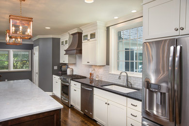 Example of a mid-sized classic dark wood floor eat-in kitchen design in Columbus with an undermount sink, recessed-panel cabinets, white cabinets, granite countertops, white backsplash, ceramic backsplash, stainless steel appliances and an island