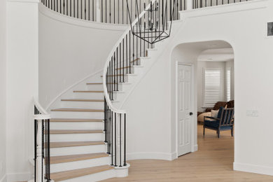 Staircase - large modern curved metal railing staircase idea in Los Angeles