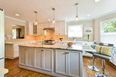 Example of a mid-sized transitional u-shaped light wood floor eat-in kitchen design in DC Metro with an undermount sink, shaker cabinets, gray cabinets, granite countertops, gray backsplash, ceramic backsplash, stainless steel appliances and an island