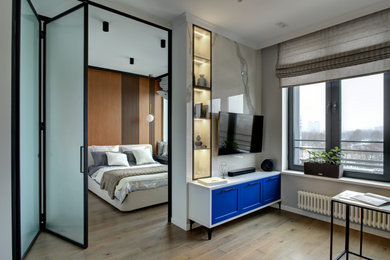 Diseño de salón blanco y madera actual pequeño con paredes grises, suelo de madera clara, televisor colgado en la pared, suelo beige y panelado