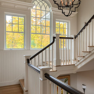 Diseño de escalera en U, costera, con escalones de madera, contrahuellas de madera pintada y barandilla de madera