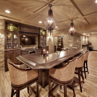 Imagen de bar en casa con barra de bar de galera, mediterráneo, con armarios con paneles con relieve y puertas de armario de madera en tonos medios