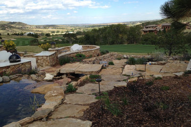 Design ideas for a large transitional backyard stone pond in Denver.