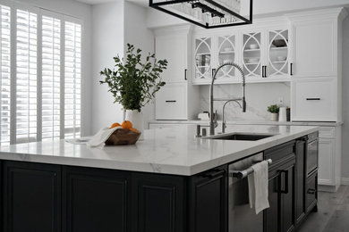 Example of a mid-sized trendy l-shaped vinyl floor and gray floor open concept kitchen design in Orange County with an undermount sink, recessed-panel cabinets, white cabinets, marble countertops, white backsplash, marble backsplash, stainless steel appliances, an island and white countertops