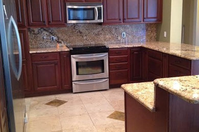 Large transitional u-shaped ceramic tile eat-in kitchen photo in Tampa with an undermount sink, medium tone wood cabinets, granite countertops, stainless steel appliances and a peninsula