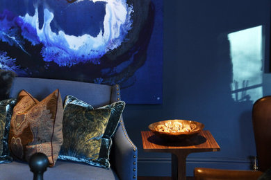 Diseño de salón para visitas tradicional de tamaño medio con paredes azules, suelo de madera en tonos medios, estufa de leña, marco de chimenea de madera, televisor colgado en la pared y suelo marrón