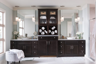 Inspiration for a large transitional master multicolored tile and marble tile ceramic tile and white floor alcove shower remodel in New York with recessed-panel cabinets, brown cabinets, blue walls, solid surface countertops and a hinged shower door