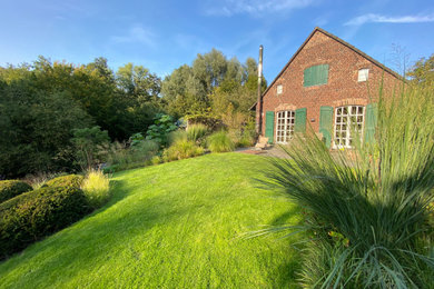 Diseño de jardín de estilo de casa de campo grande en verano en ladera con exposición total al sol