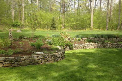 Photo of a traditional backyard mulch retaining wall landscape in New York.