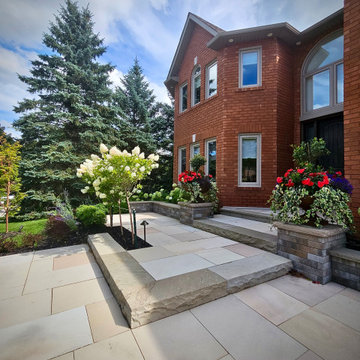 Layered Front Entrance with Natural Stone Steps and Custom Planters