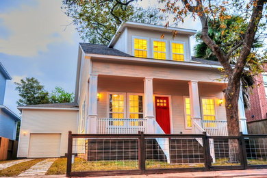 Example of a mid-sized arts and crafts beige two-story wood exterior home design in Houston with a shingle roof