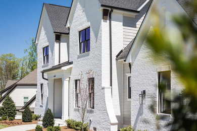 Large modern white brick exterior home idea in Charlotte with a shingle roof