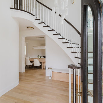 Grand Curved Staircase with Black Arched Doors and Floating Light Fixtures