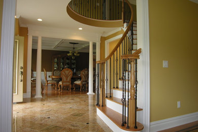 Example of a large tuscan wooden curved metal railing staircase design in New York with wooden risers