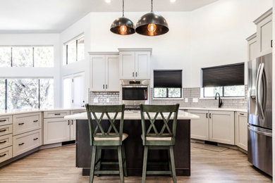 Example of a large transitional u-shaped vinyl floor and gray floor eat-in kitchen design in Other with an undermount sink, shaker cabinets, gray cabinets, quartzite countertops, green backsplash, subway tile backsplash, stainless steel appliances, an island and white countertops