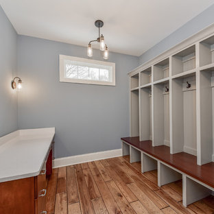 На фото: тамбур среднего размера в стиле современная классика с серыми стенами, одностворчатой входной дверью, входной дверью из дерева среднего тона, полом из ламината и коричневым полом с