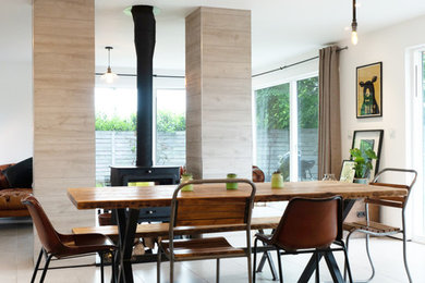 Photo of a medium sized urban open plan dining room in West Midlands with white walls, a wood burning stove and a tiled fireplace surround.
