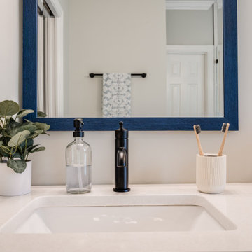 Vanity Counter Detail with Matte Black Faucet and Blue Mirror Frame