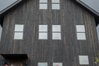 Minimalist black two-story wood gable roof photo in Seattle