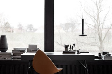 Example of a mid-sized danish freestanding desk light wood floor and brown floor home office design in San Francisco with black walls