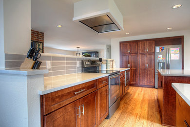 Example of a mid-sized trendy galley medium tone wood floor open concept kitchen design in Seattle with shaker cabinets, medium tone wood cabinets, quartz countertops, gray backsplash, porcelain backsplash and an island